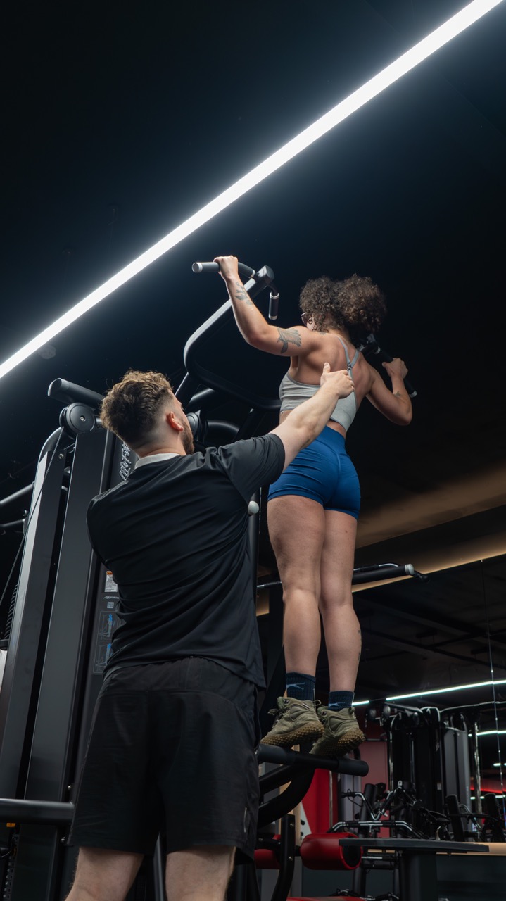 Elliott spotting a client on assisted pull-ups